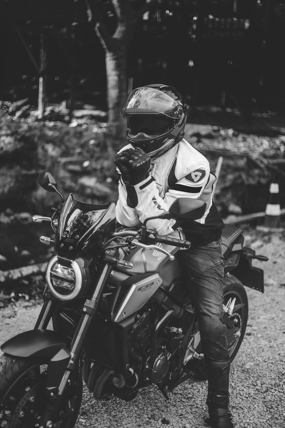 grayscale photo of man in motorcycle helmet riding motorcycle