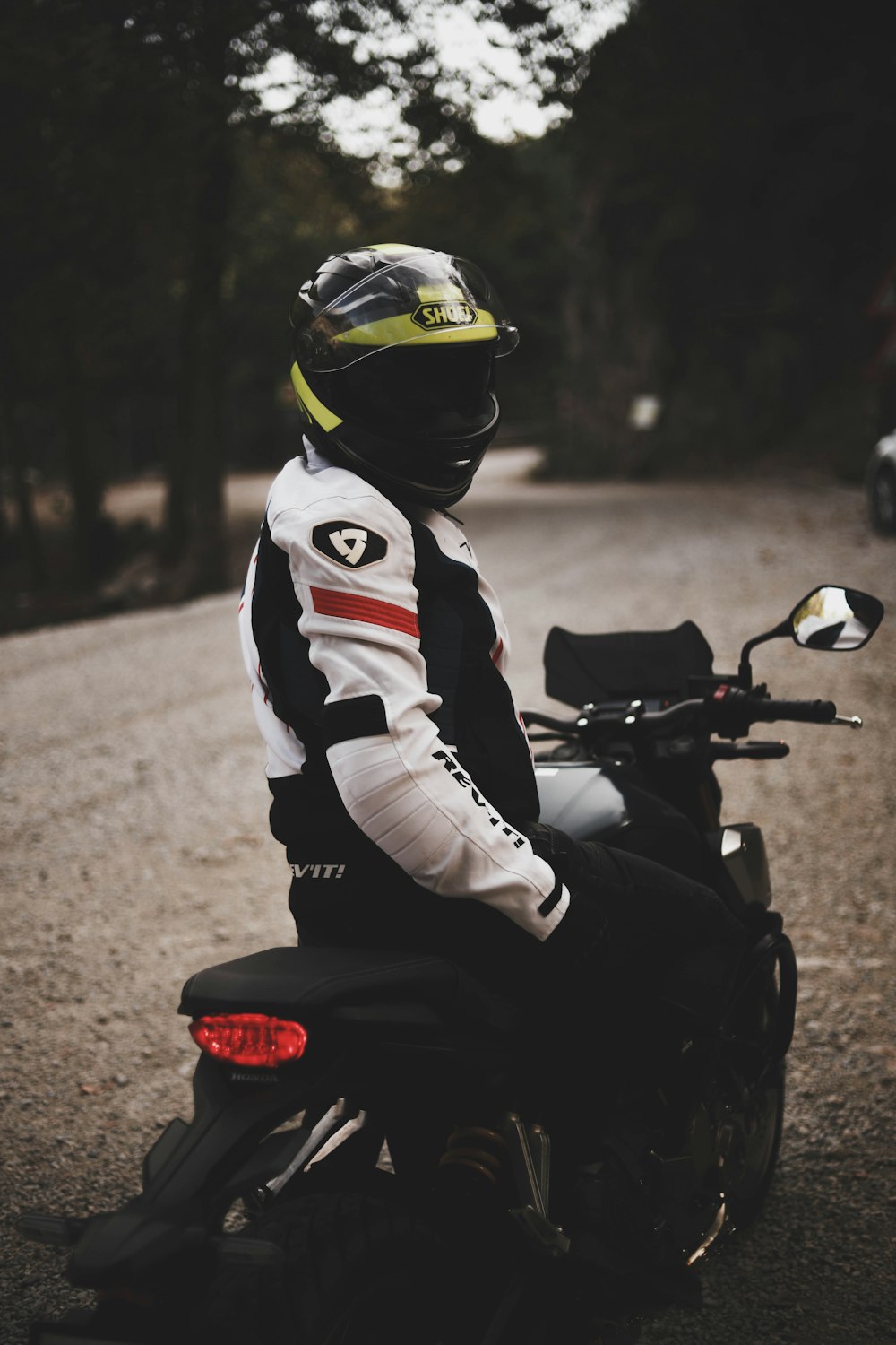 person in white red and black motorcycle helmet riding on black motorcycle during daytime