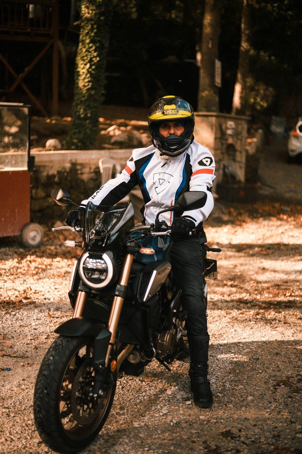 man in white and black motorcycle suit riding motorcycle during daytime