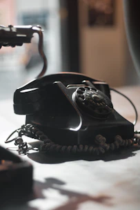 Close-up of hands holding a vintage telephone receiver with soft warm lighting.
