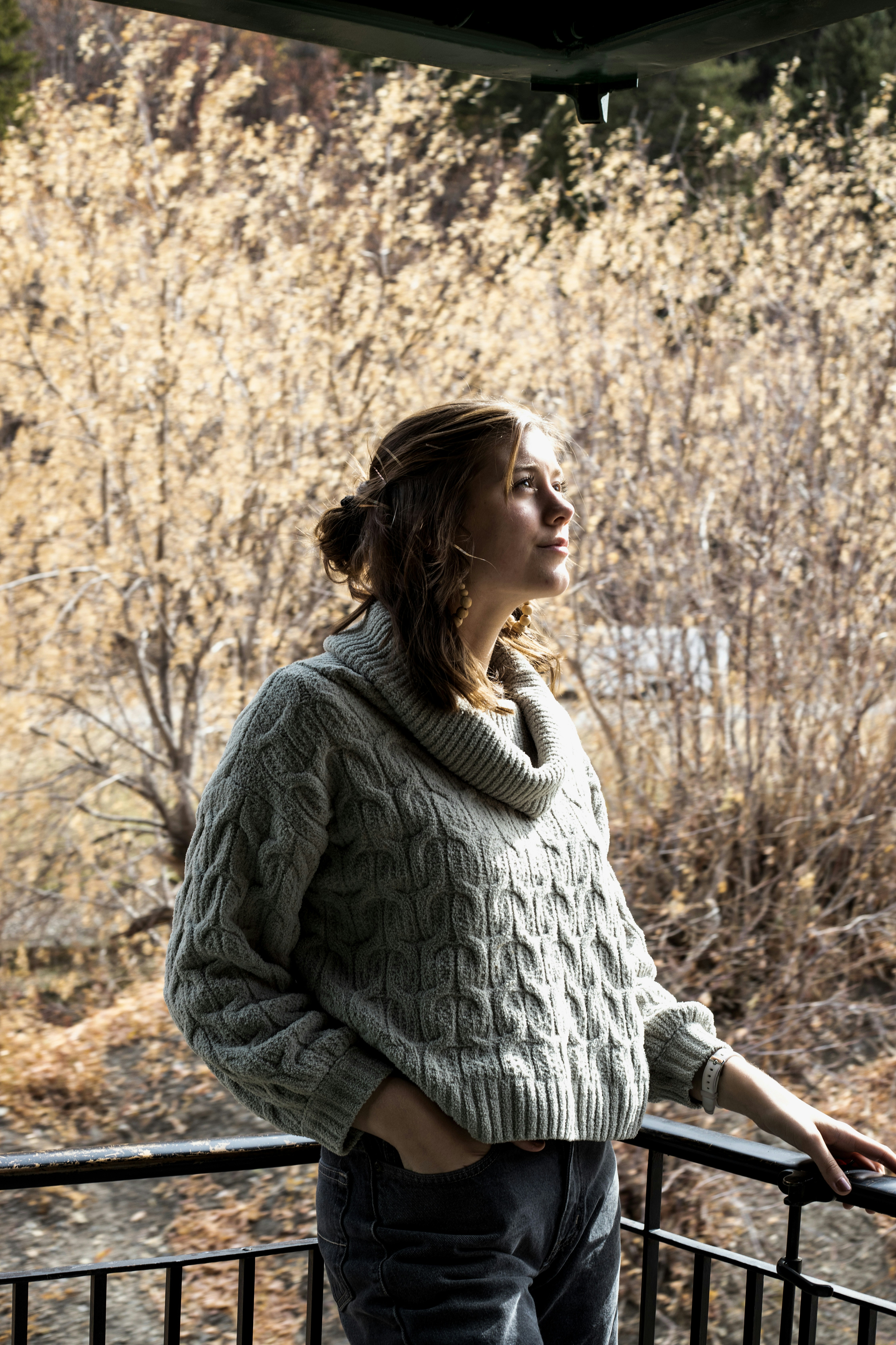 woman in black and white striped long sleeve shirt standing near brown trees during daytime