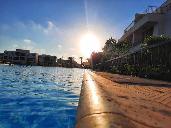 A beautifully designed modern swimming pool in a Riyadh backyard at sunset.