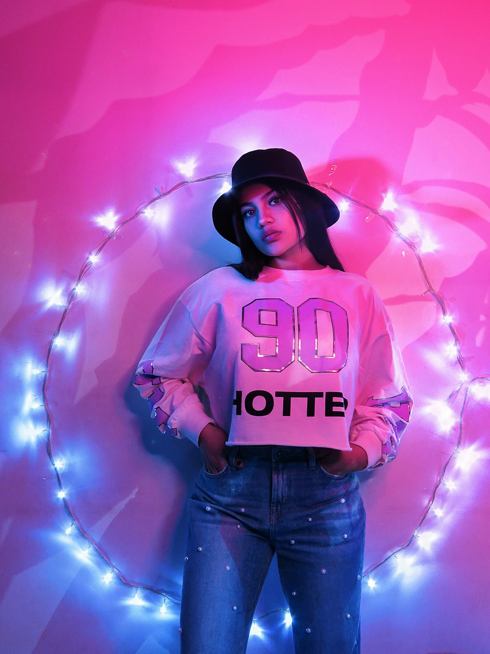 woman in pink and white long sleeve shirt and blue denim jeans standing