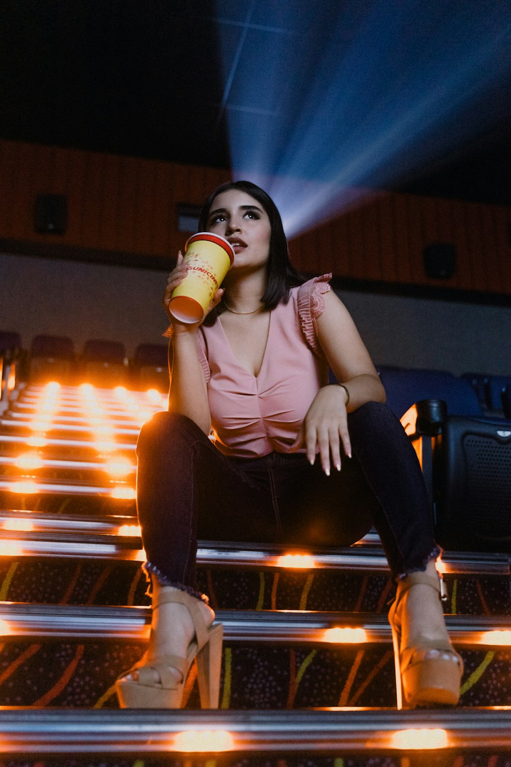 woman in beige tank top and black pants sitting on chair