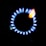 A stove burner with a ring of blue flames surrounding a central black disc, with a hint of orange flame visible at one spot.