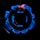 A close-up view of a stove burner with a blue flame. The flame forms a ring around the central burner, displaying an intricate pattern. The black metal grates of the stove are visible above the flame, contrasting sharply with the bright blue color.