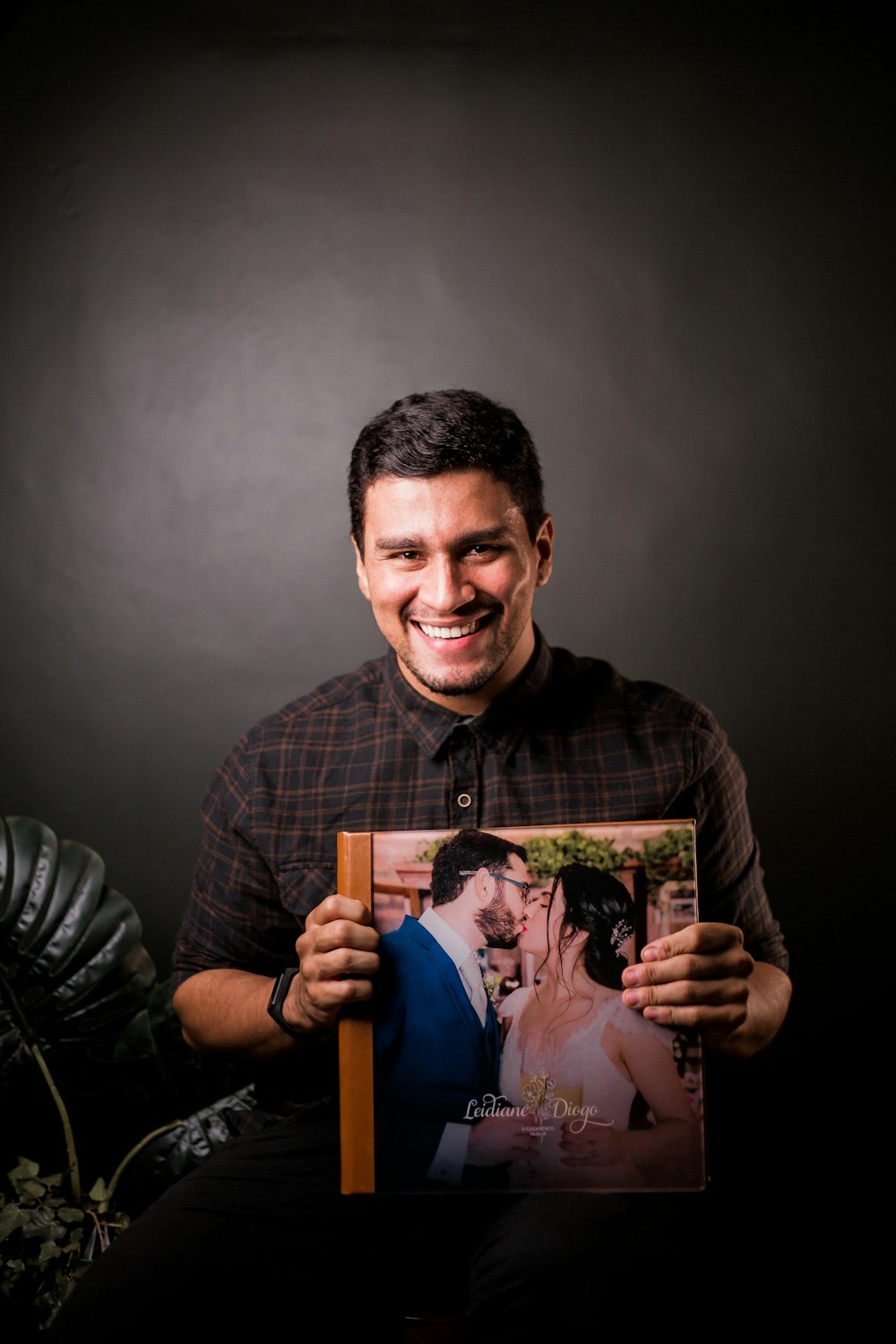 man in black and white striped long sleeve shirt holding picture of baby