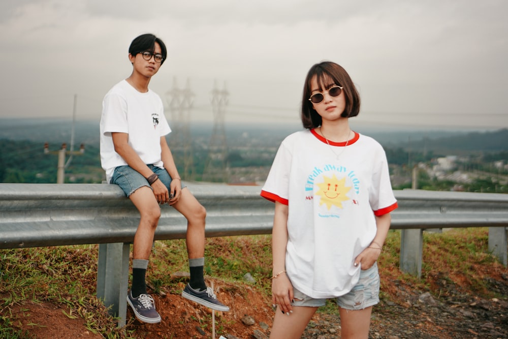 woman in white crew neck t-shirt sitting on brown wooden bench during daytime