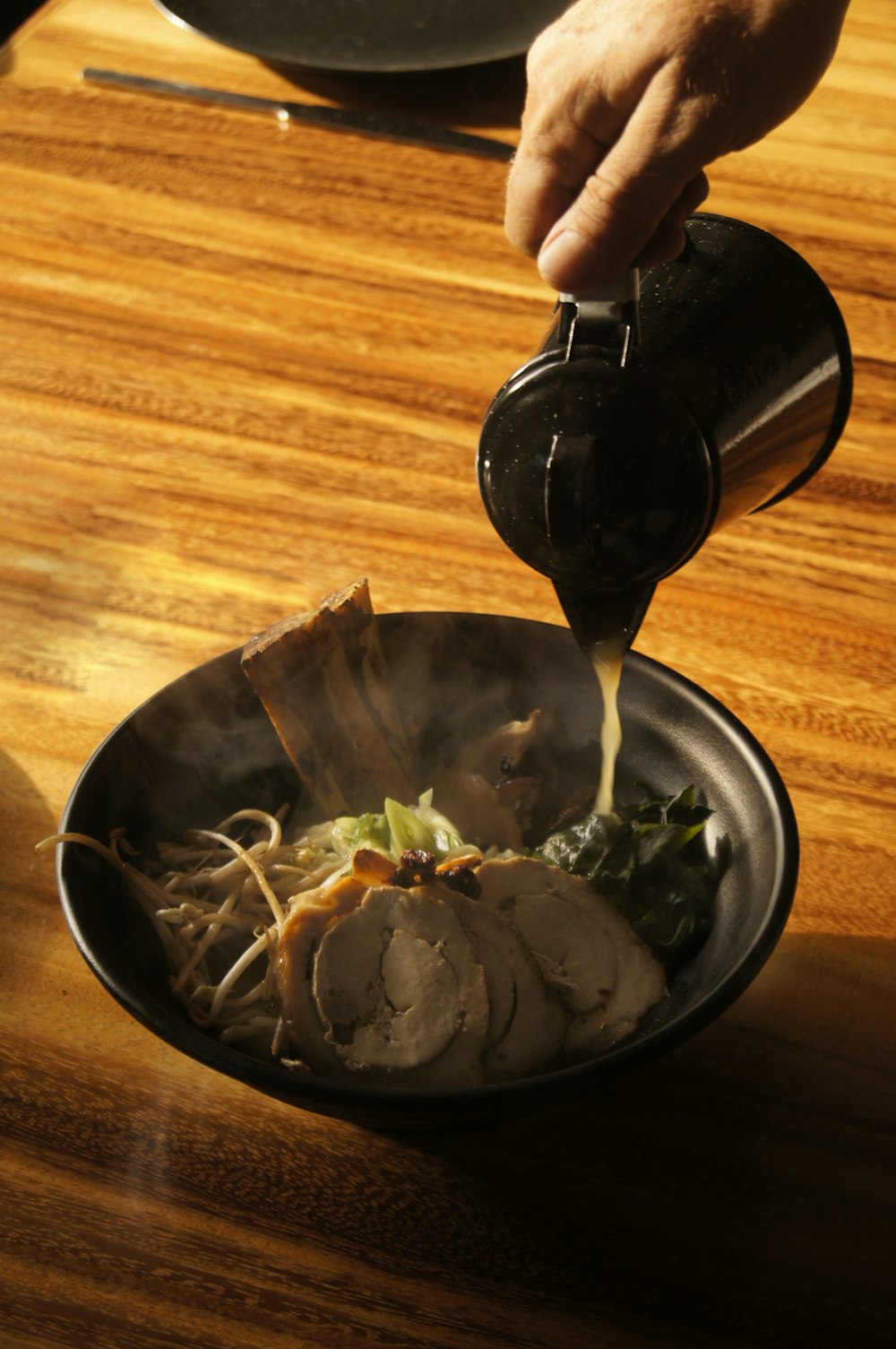 person holding black ceramic mug with food