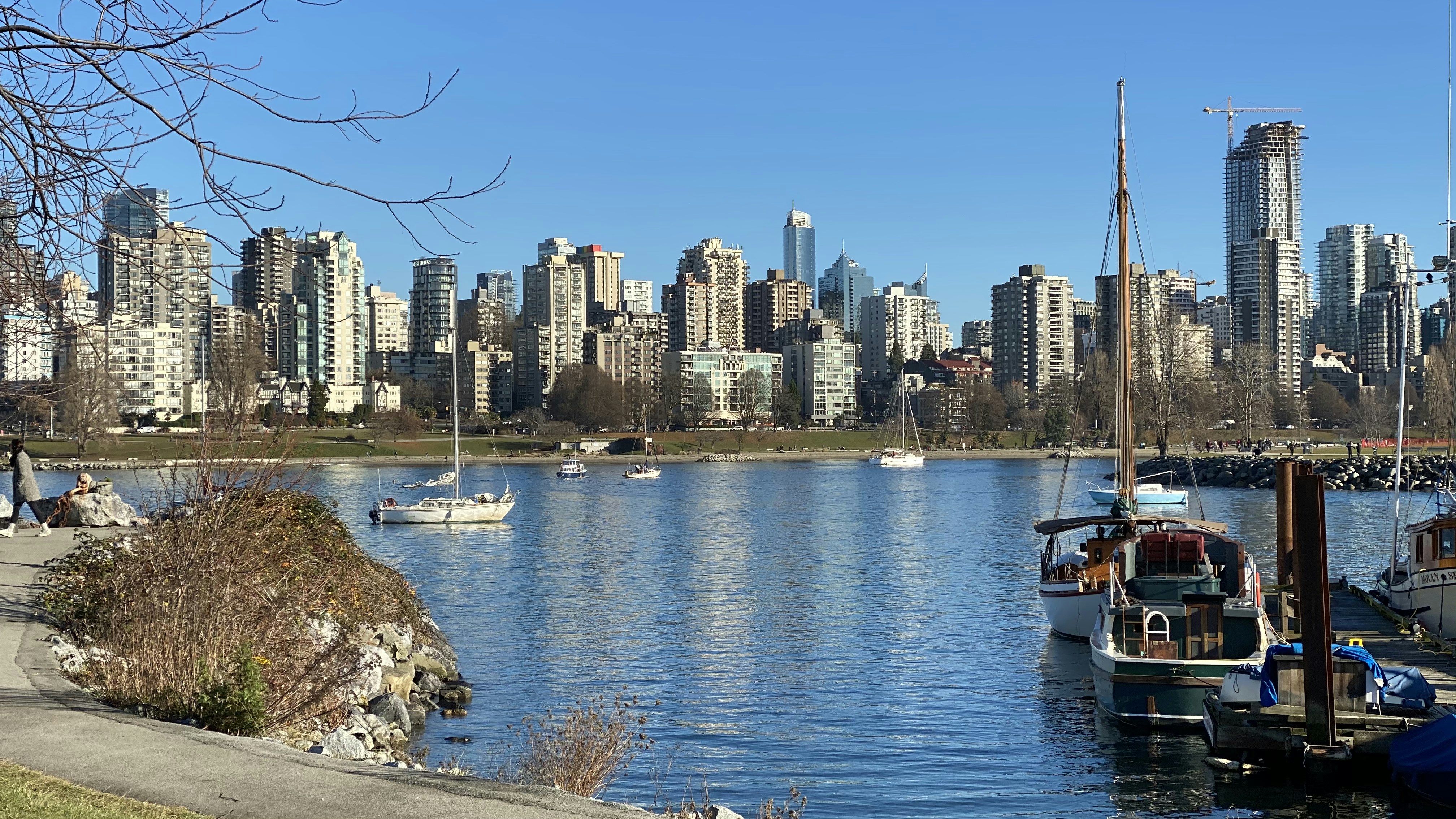 white and brown boat on body of water near city buildings during daytime