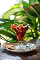 clear glass cup with red liquid on brown wooden table