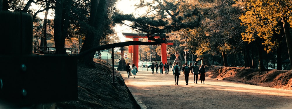 people standing near red metal frame during daytime