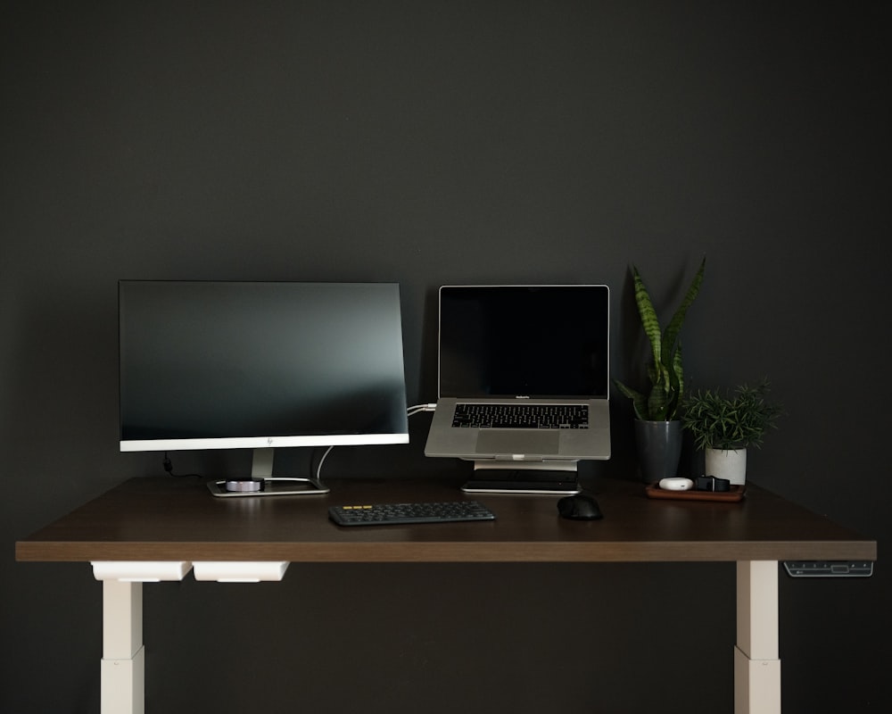 silver flat screen computer monitor on brown wooden desk