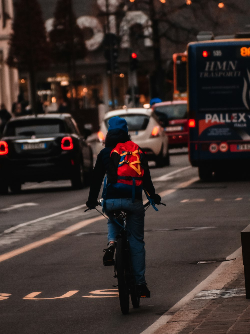 man in blue denim jeans and black backpack walking on pedestrian lane during daytime