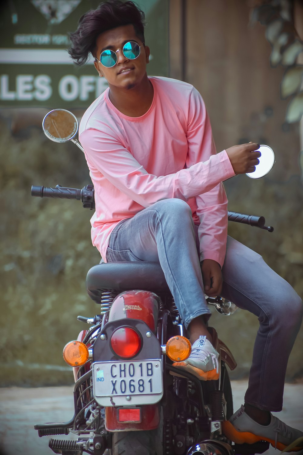 man in pink dress shirt riding on red motorcycle during daytime