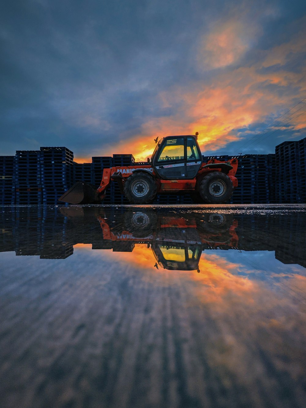a tractor parked in front of stacks of crates