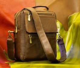 black leather sling bag on yellow leather chair
