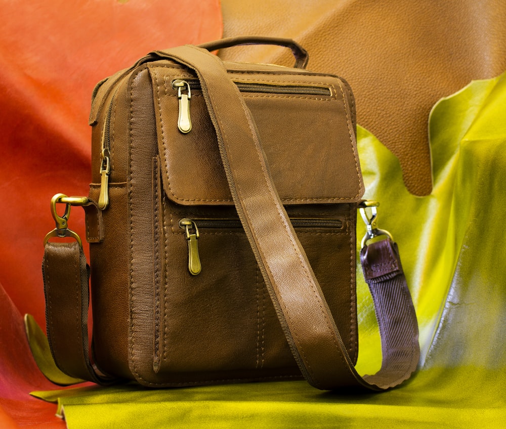 black leather sling bag on yellow leather chair