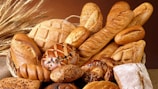 A basket filled with assorted sourdough breads, showcasing different shapes and textures.