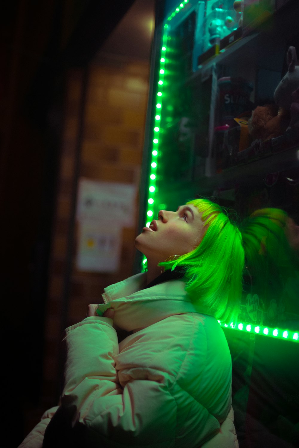 woman in white jacket with green hair