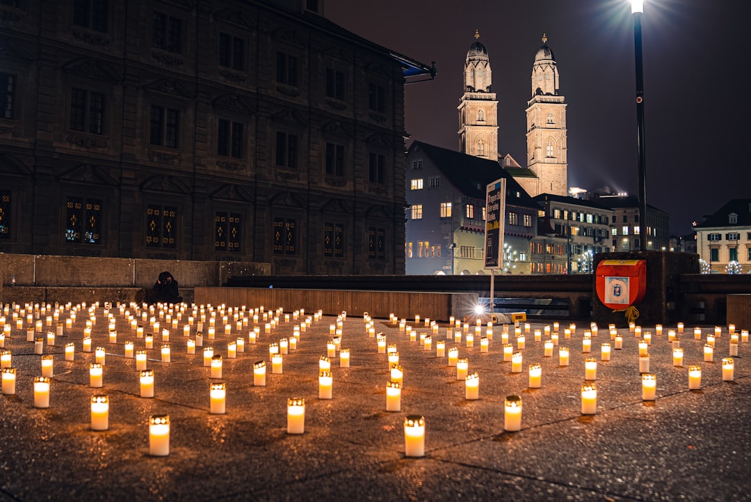 lighted candles on street near brown concrete building during night time