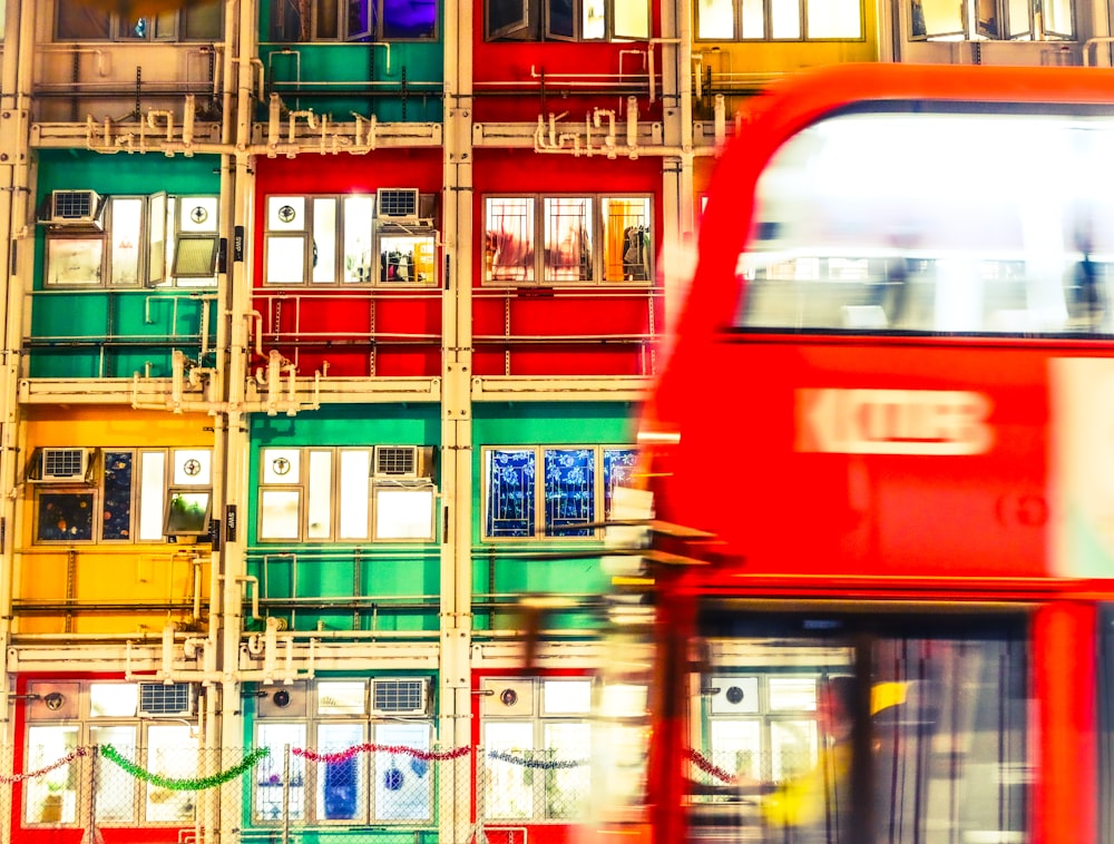 red and blue bus in front of building