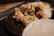 Close-up of a plate piled high with crispy whole chicken wings, macaroni &amp;amp;amp;amp;amp; cheese, and a slice of peach cobbler on a rustic wooden table.