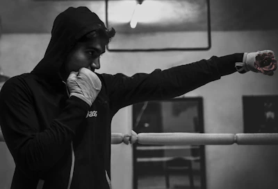 A fighter practicing striking techniques in a modern MMA gym with bright lighting.