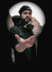 man in black jacket holding black camera