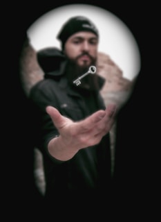 man in black jacket holding black camera