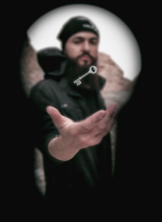 man in black jacket holding black camera