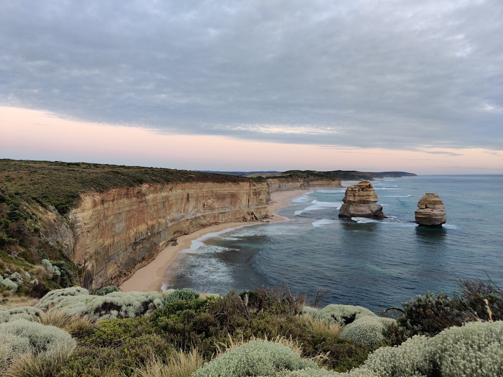 brown rock formation near body of water during daytime