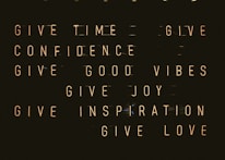 A series of motivational phrases are displayed in neon-style text against a dark background. The phrases include 'give time', 'give confidence', 'give good vibes', 'give joy', 'give inspiration', and 'give love'. The words are arranged in a structured, grid-like format, creating a visually impactful and positive message.