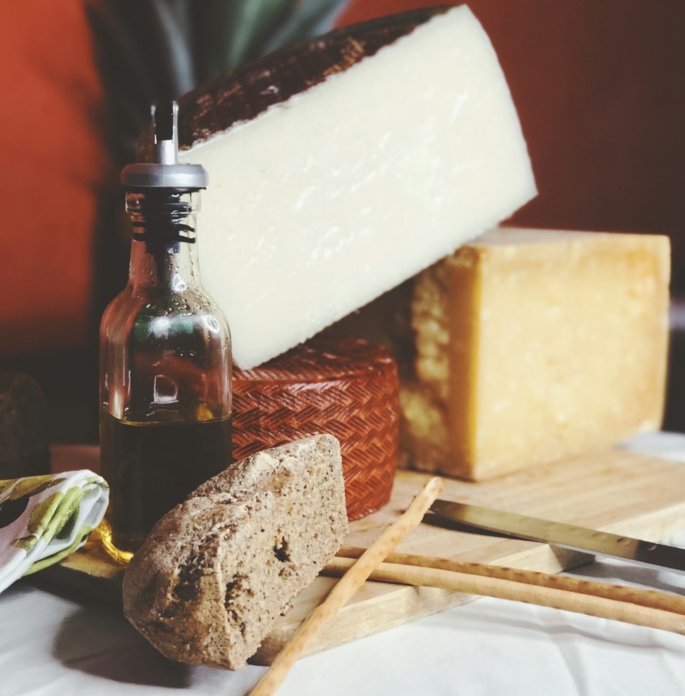 sliced bread on white ceramic plate beside brown glass bottle