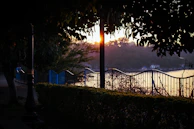 Sunset casting warm light over a freshly trimmed lawn with Trimly resting nearby.