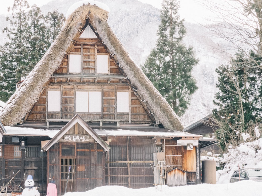 braunes Holzhaus tagsüber mit Schnee bedeckt