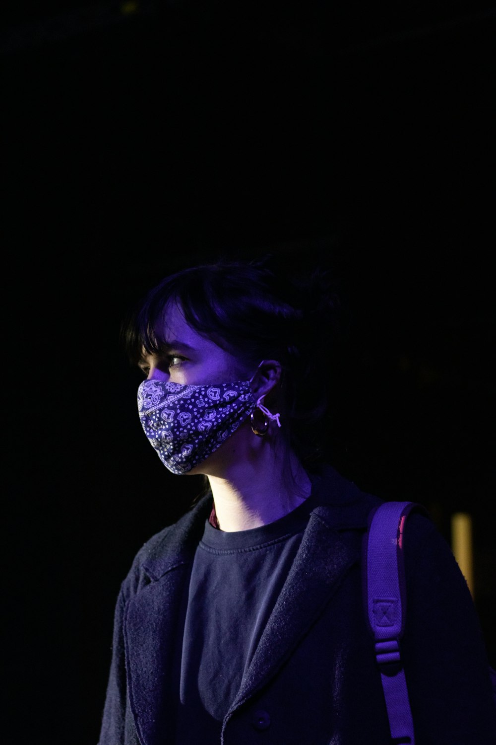 Femme en chemise à col rond noir avec peinture faciale violette et bleue