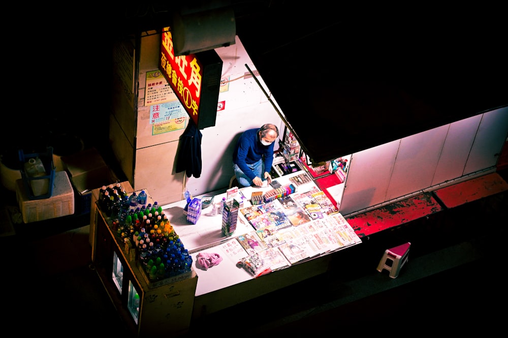 Femme en chemise bleue à manches longues debout à côté du comptoir