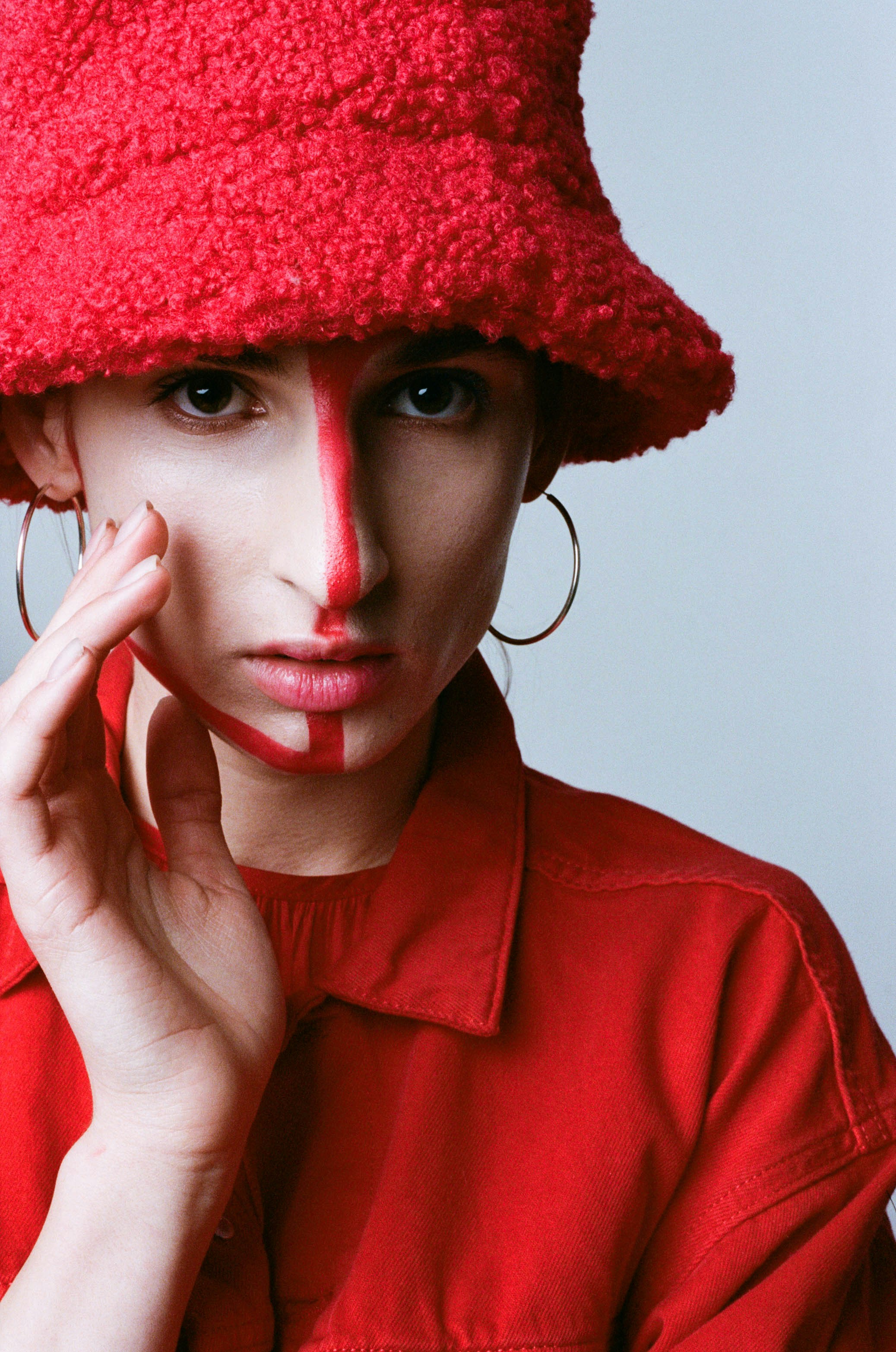 Mujer con camisa roja abotonada con gorra de punto roja