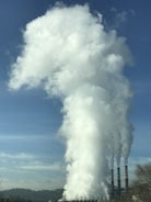 A modern thermal power plant with smoke stacks under a clear blue sky