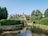 A serene view of a stone-built shepherd's cottage surrounded by lush greenery.