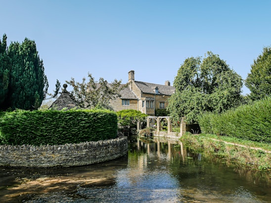A picturesque view of the historic Buttery Cottage surrounded by lush greenery.
