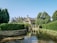 A serene view of a stone-built shepherd's cottage surrounded by lush greenery.