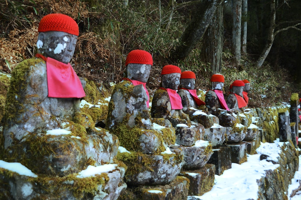 Personas con chaqueta roja y negra de pie en el suelo cubierto de nieve durante el día