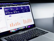 A laptop screen showing CRM software with sales data and AI tools.