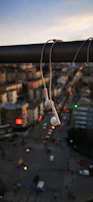 Sleek premium headphones resting on a concrete ledge with city skyline.