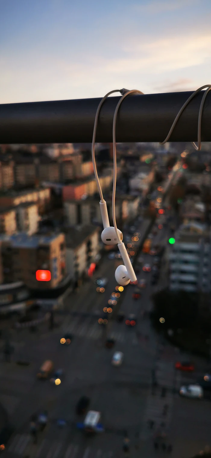 A pair of earpods on a black string, the visual shorthand of modern connection