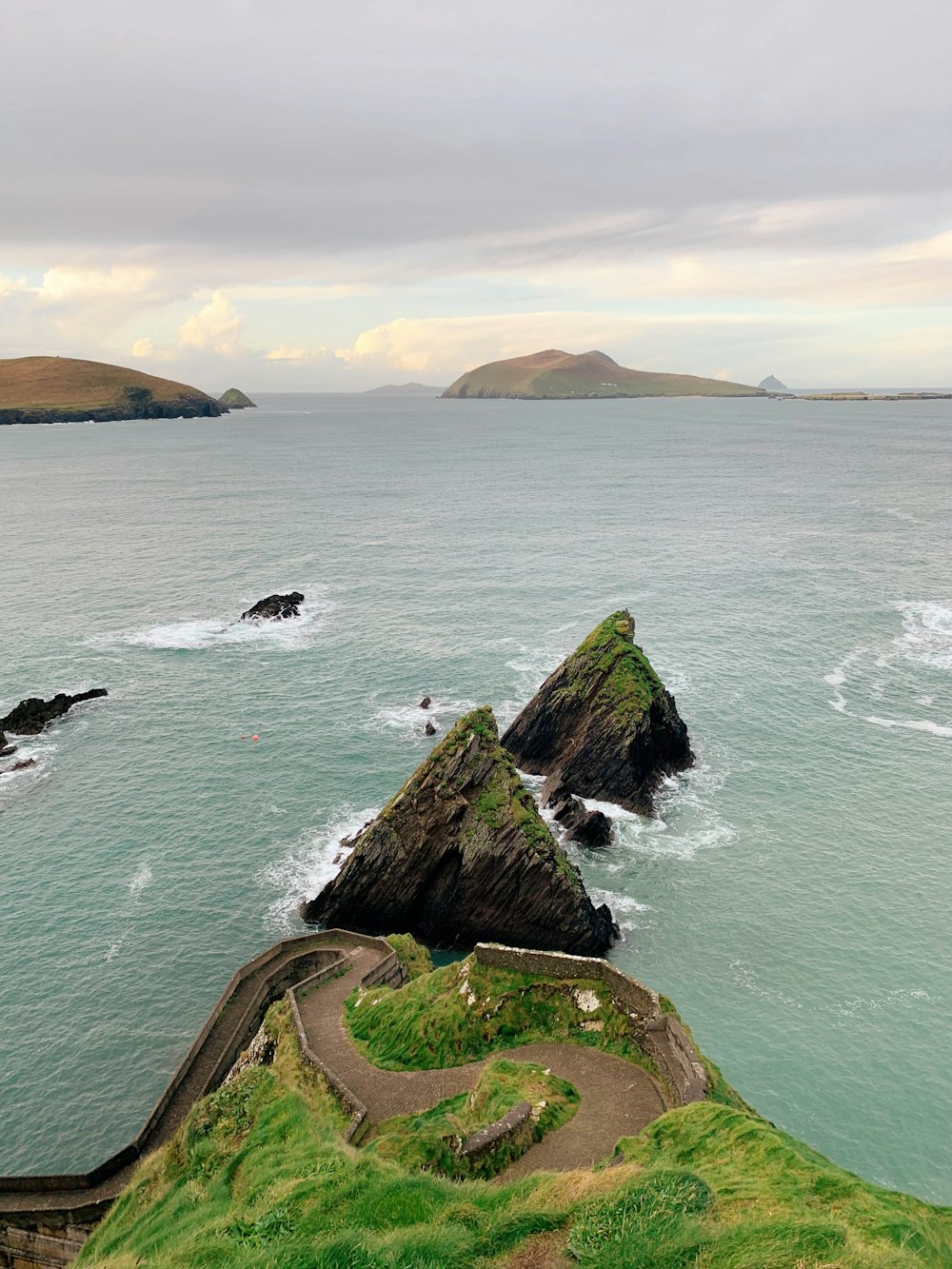 green and brown rock formation on sea during daytime