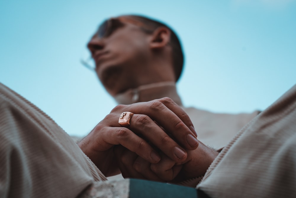 man in white long sleeve shirt covering his face with his hand