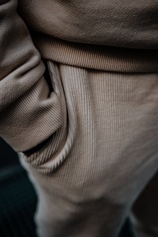 Close-up of hands feeling soft fabric of a pair of shorts, highlighting quality and texture.